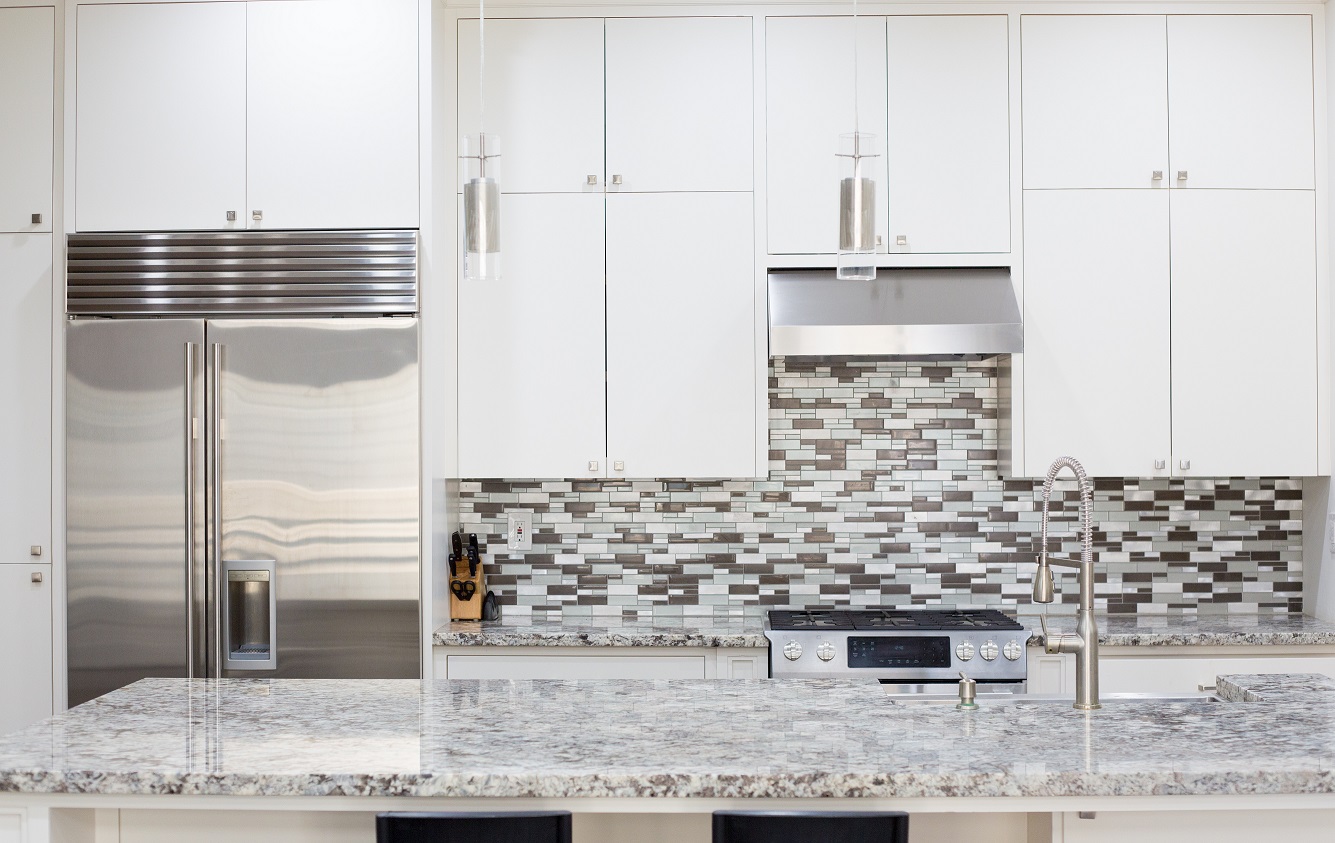 gray kitchen with gray kitchen countertops and gray/blue patterned backsplash