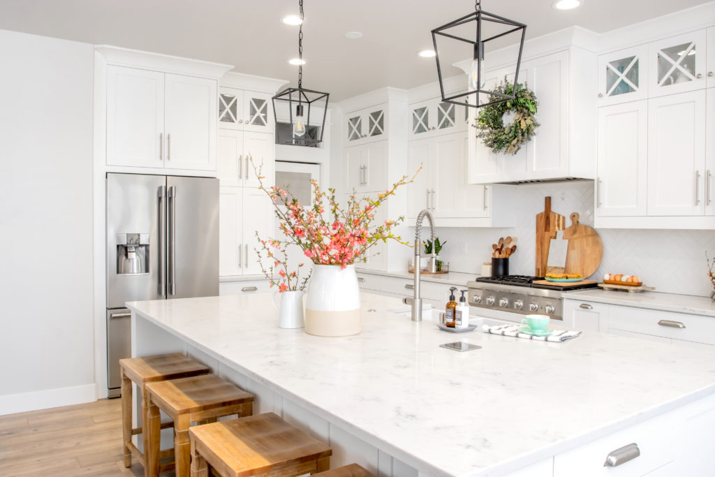 A big vase full of flowering branches in the on the countertop of a modern farmhouse kitchen.