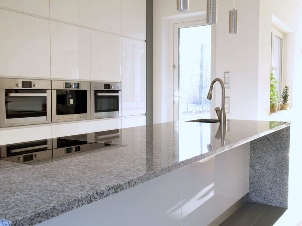A new granite countertop in a large white kitchen in El Paso.